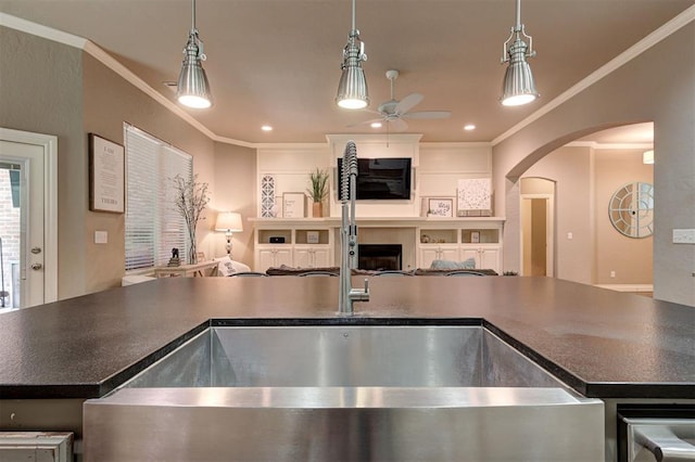 2473 Vellano Ln, Edmond, OK 73034 - kitchen with arched walkways, a ceiling fan, open floor plan, crown molding, and dark countertops