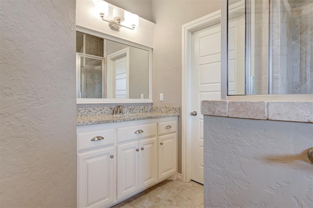 2473 Vellano Ln, Edmond, OK 73034 - bathroom featuring a textured wall, vanity, and tiled shower
