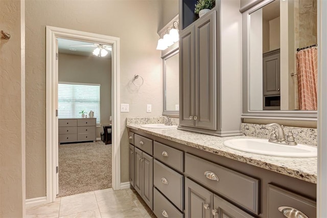 2473 Vellano Ln, Edmond, OK 73034 - full bathroom with double vanity, a textured wall, a ceiling fan, and tile patterned flooring
