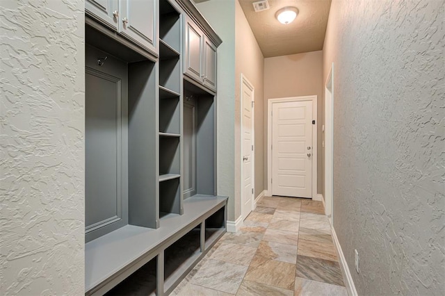 2473 Vellano Ln, Edmond, OK 73034 - mudroom featuring a textured wall and light stone finish floors