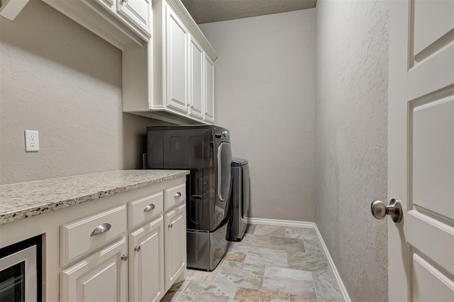 2473 Vellano Ln, Edmond, OK 73034 - washroom featuring washer and dryer, cabinet space, and a textured wall