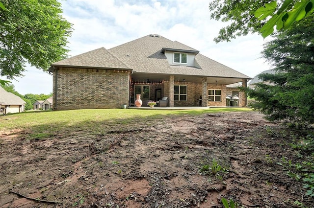 2473 Vellano Ln, Edmond, OK 73034 - back of house featuring brick siding, a shingled roof, and a lawn