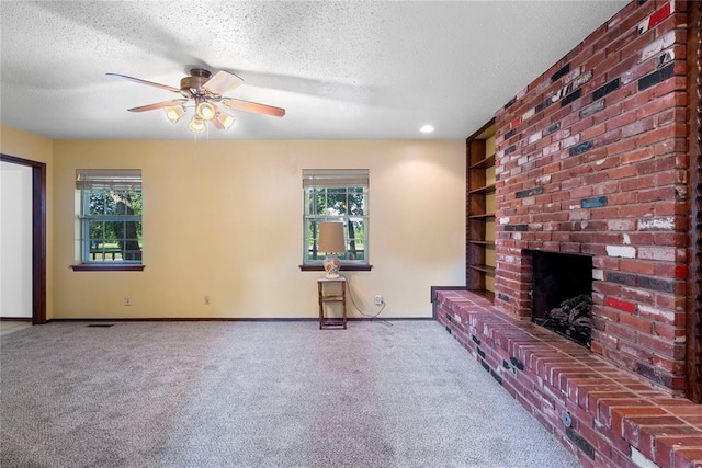 1317 Sue Ln, Choctaw, OK 73020 - unfurnished living room featuring a textured ceiling, carpet floors, ceiling fan, a brick fireplace, and built in features