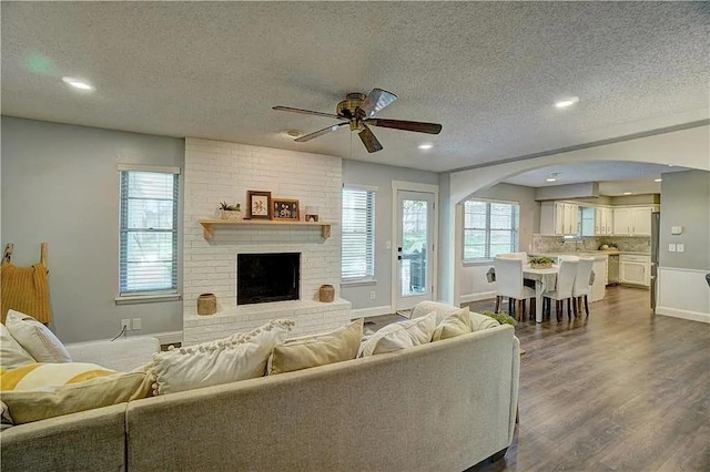 1013 Mary Lee Ln, Edmond, OK 73034 - living room with a textured ceiling, ceiling fan, arched walkways, healthy amount of natural light, and dark wood-style floors