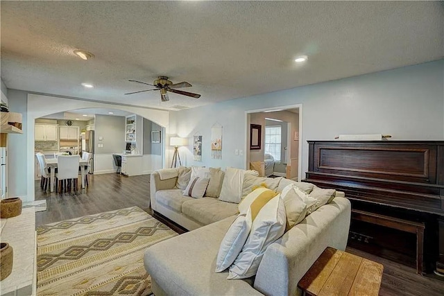 1013 Mary Lee Ln, Edmond, OK 73034 - living area with arched walkways, a textured ceiling, dark wood-style floors, a ceiling fan, and recessed lighting