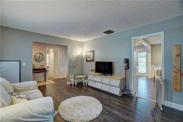 1013 Mary Lee Ln, Edmond, OK 73034 - living area with wood finished floors, a textured ceiling, and arched walkways