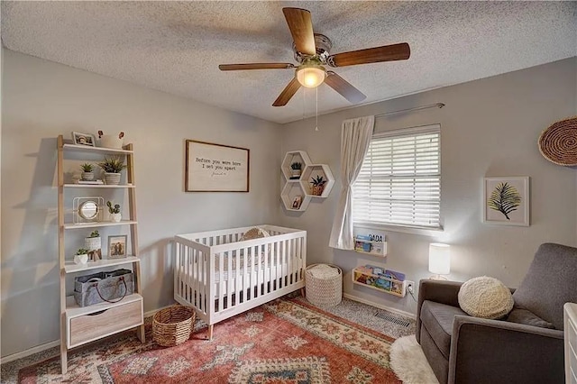 1013 Mary Lee Ln, Edmond, OK 73034 - carpeted bedroom with a nursery area, a textured ceiling, and a ceiling fan