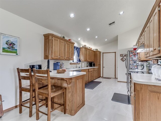 975 Garden Rd, Tuttle, OK 73089 - kitchen with a peninsula, light countertops, a kitchen bar, recessed lighting, and vaulted ceiling