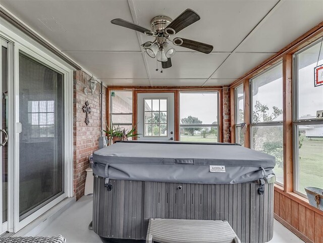 975 Garden Rd, Tuttle, OK 73089 - sunroom with a hot tub, a ceiling fan, brick wall, and finished concrete floors