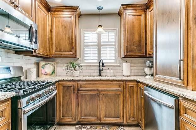 801 Belle Air Ave, Edmond, OK 73013 - kitchen featuring stainless steel appliances, decorative backsplash, and light stone counters