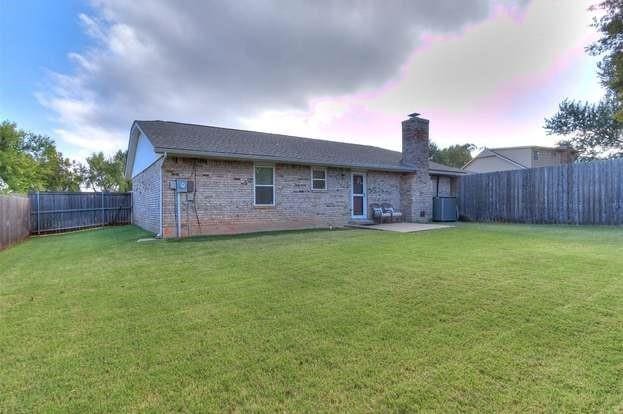 801 Belle Air Ave, Edmond, OK 73013 - rear view of property featuring a fenced backyard, brick siding, a chimney, and a patio