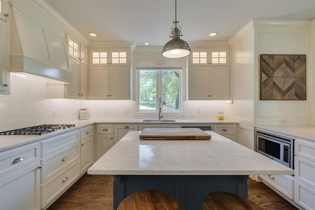 1300 Oak Springs Ln, Edmond, OK 73034 - kitchen with appliances with stainless steel finishes, dark wood finished floors, custom exhaust hood, white cabinetry, and crown molding