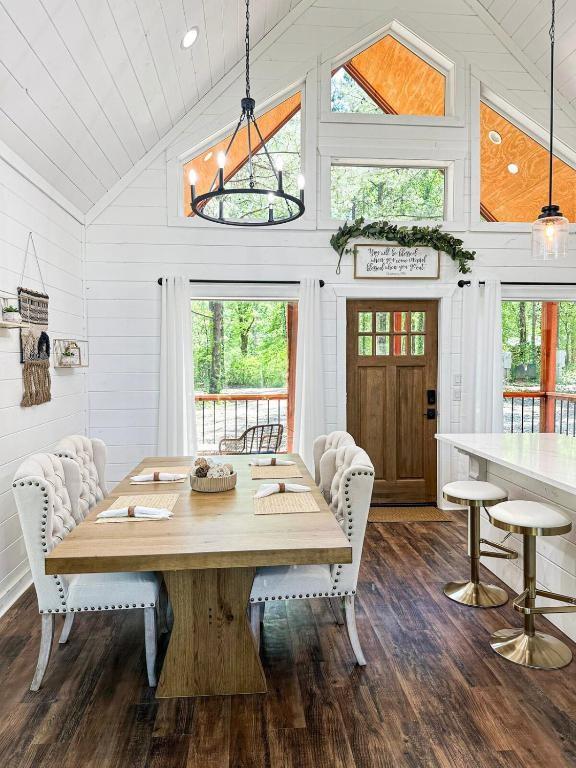 142 Champion Way, Broken Bow, OK 74728 - dining area with lofted ceiling, wooden ceiling, dark wood-style flooring, plenty of natural light, and wooden walls