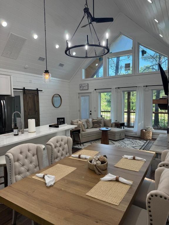 142 Champion Way, Broken Bow, OK 74728 - dining area with a barn door, high vaulted ceiling, recessed lighting, a chandelier, and wood walls