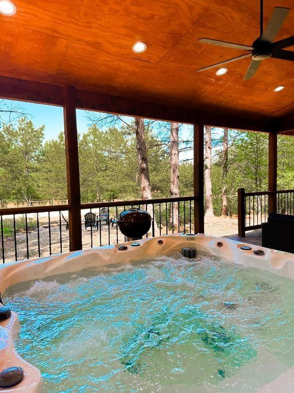 142 Champion Way, Broken Bow, OK 74728 - wooden terrace featuring a hot tub, ceiling fan, and a grill