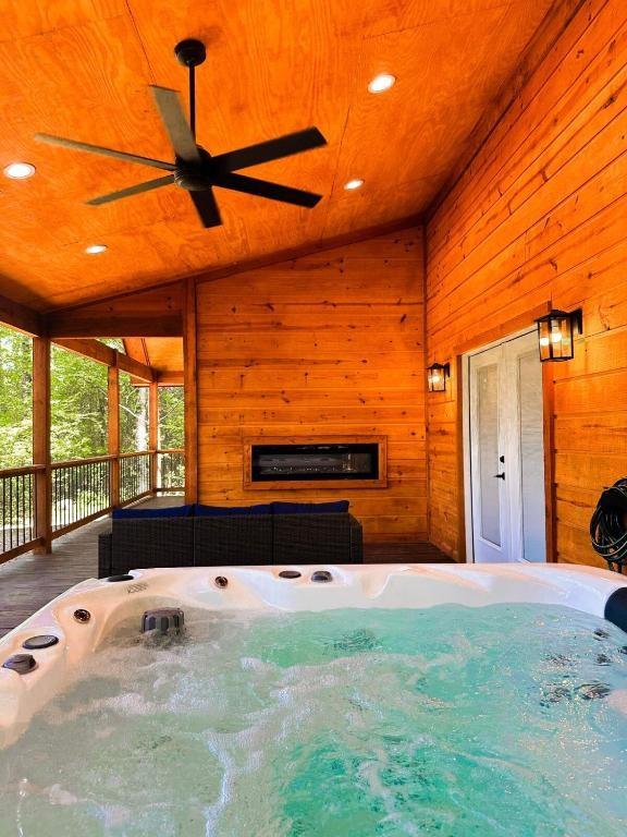 142 Champion Way, Broken Bow, OK 74728 - exterior space featuring vaulted ceiling, a hot tub, wood walls, ceiling fan, and wooden ceiling