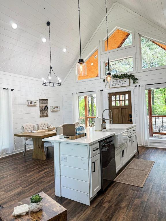 142 Champion Way, Broken Bow, OK 74728 - kitchen with dishwashing machine, light countertops, dark wood-style floors, high vaulted ceiling, and hanging light fixtures
