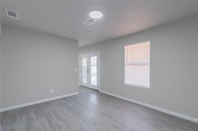spare room with wood finished floors and french doors