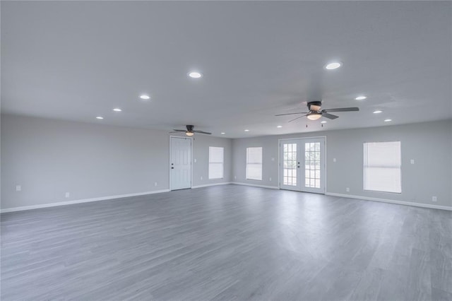unfurnished living room with ceiling fan, wood finished floors, recessed lighting, and french doors