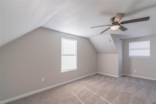 bonus room featuring vaulted ceiling, ceiling fan, carpet floors, and a textured ceiling