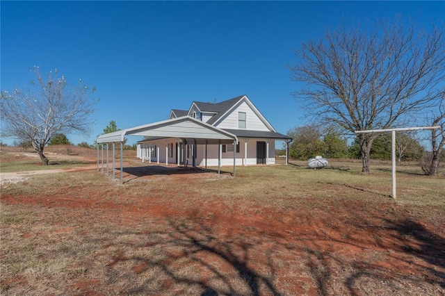 farmhouse inspired home featuring a detached carport and a front lawn
