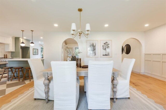 1112 Mary Lee Ln, Edmond, OK 73034 - dining space with light wood-type flooring, arched walkways, recessed lighting, and a chandelier