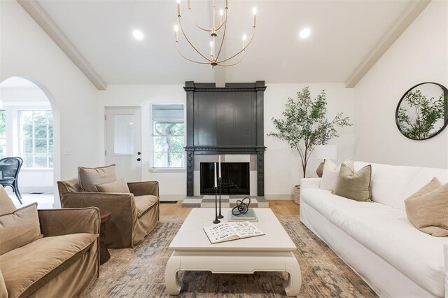 1112 Mary Lee Ln, Edmond, OK 73034 - living room featuring arched walkways, a fireplace with raised hearth, a chandelier, light wood-style floors, and recessed lighting