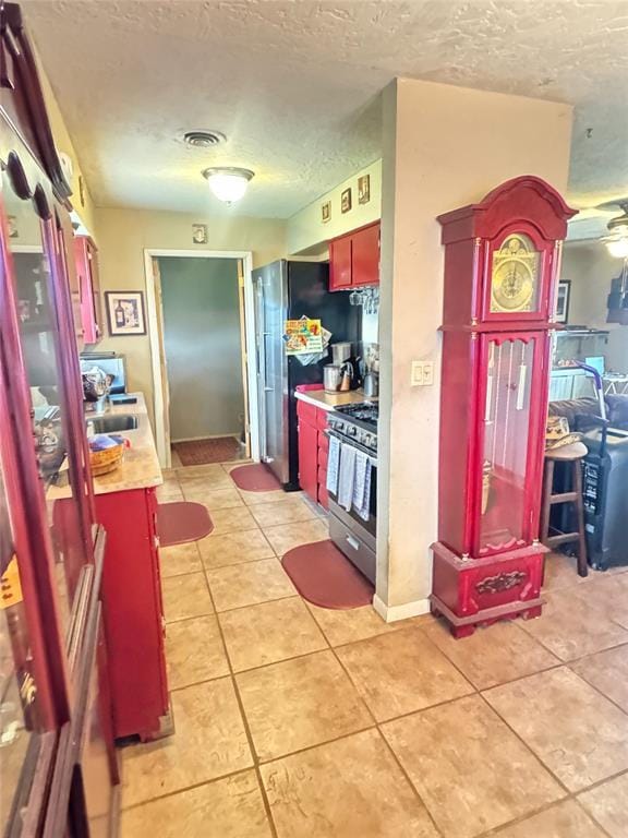 4306 NW Williams Ave, Lawton, OK 73505 - kitchen with appliances with stainless steel finishes, a textured ceiling, light countertops, and light tile patterned flooring