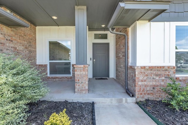 1108 Blackjack Creek Dr, Yukon, OK 73099 - view of exterior entry featuring board and batten siding, brick siding, and covered porch