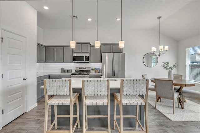 1108 Blackjack Creek Dr, Yukon, OK 73099 - kitchen with appliances with stainless steel finishes, gray cabinets, backsplash, a chandelier, and recessed lighting