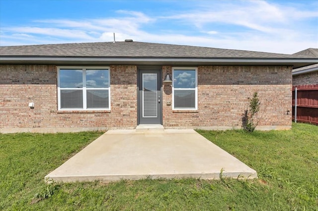 1108 Blackjack Creek Dr, Yukon, OK 73099 - doorway to property featuring a lawn, a patio area, brick siding, and roof with shingles
