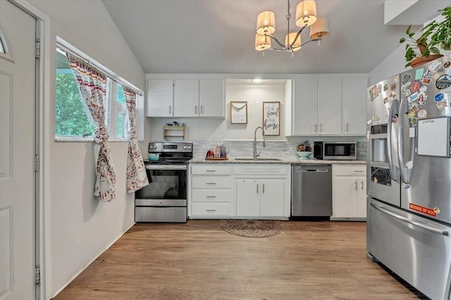 417 Garth Brooks Blvd, Yukon, OK 73099 - kitchen featuring stainless steel appliances, a chandelier, vaulted ceiling, white cabinetry, and light wood-type flooring
