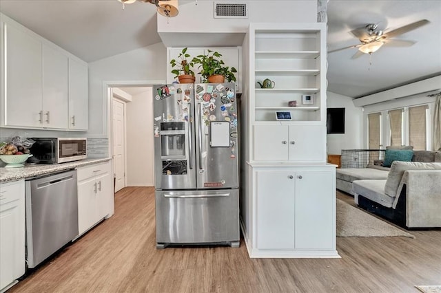 417 Garth Brooks Blvd, Yukon, OK 73099 - kitchen featuring appliances with stainless steel finishes, lofted ceiling, ceiling fan, light wood finished floors, and white cabinetry