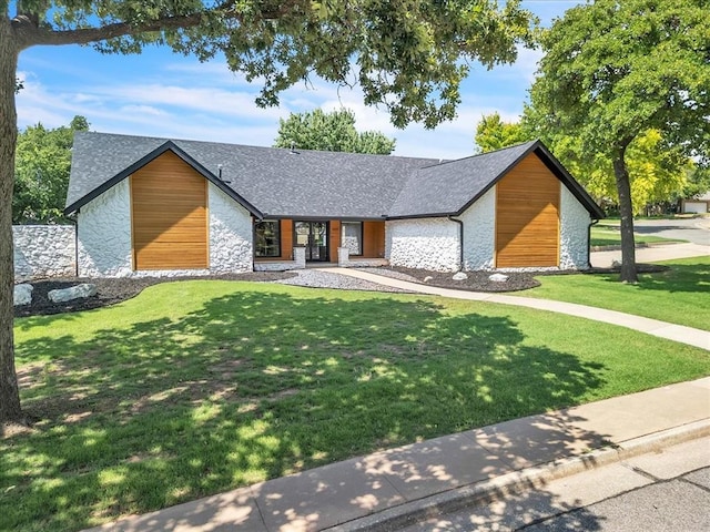1205 Shalamar Rd, Edmond, OK 73013 - view of front facade featuring stone siding, a front lawn, and roof with shingles