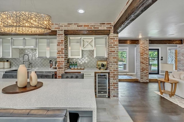 1205 Shalamar Rd, Edmond, OK 73013 - kitchen with beverage cooler, decorative backsplash, glass insert cabinets, wood finished floors, and pendant lighting