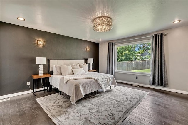 1205 Shalamar Rd, Edmond, OK 73013 - bedroom with dark wood-type flooring, a chandelier, recessed lighting, and an accent wall