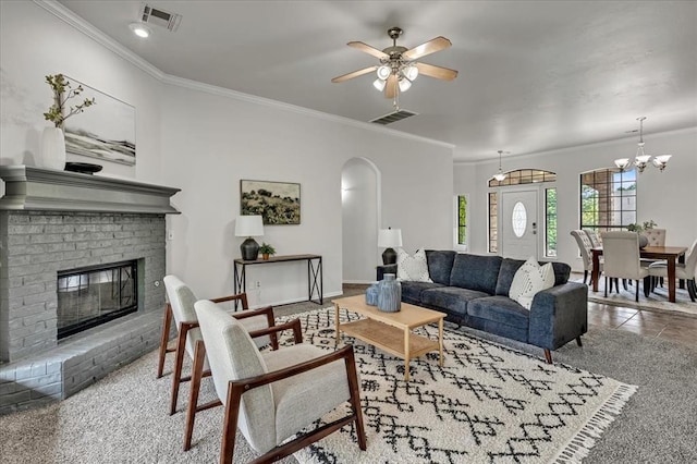 732 Tuscany Way, Edmond, OK 73034 - living room with arched walkways, ornamental molding, ceiling fan, a fireplace, and a chandelier