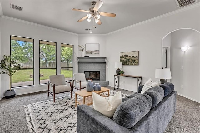 732 Tuscany Way, Edmond, OK 73034 - living area featuring carpet flooring, arched walkways, crown molding, a brick fireplace, and ceiling fan