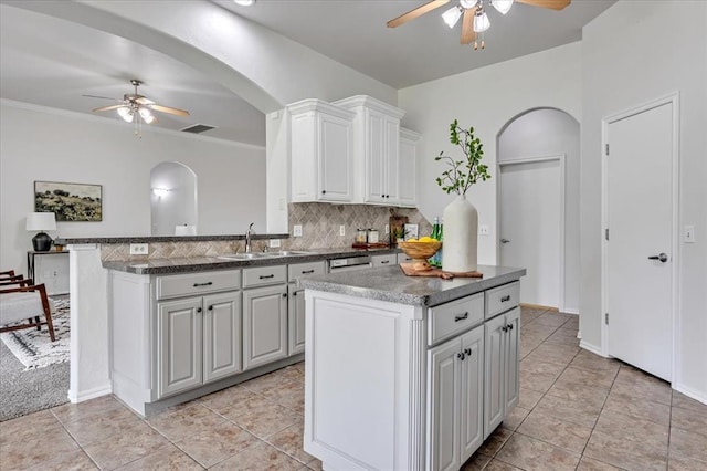 732 Tuscany Way, Edmond, OK 73034 - kitchen with ceiling fan, arched walkways, decorative backsplash, and light tile patterned floors