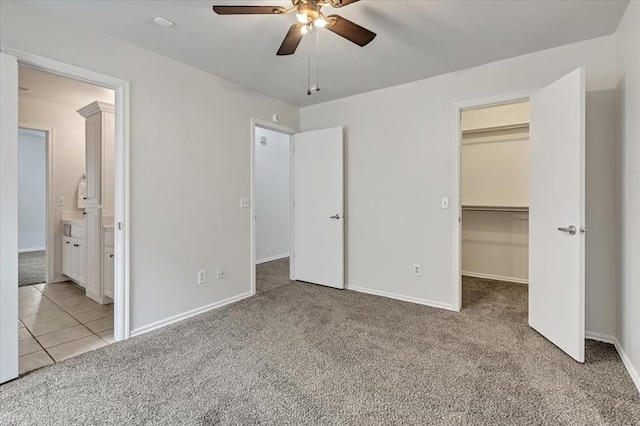 732 Tuscany Way, Edmond, OK 73034 - unfurnished bedroom with carpet floors, a spacious closet, a closet, connected bathroom, and ceiling fan