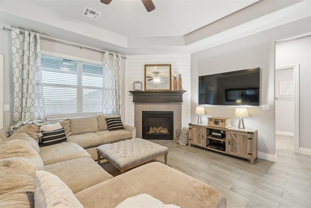 609 NW 180th St, Edmond, OK 73012 - living room featuring a ceiling fan, a glass covered fireplace, and light wood finished floors