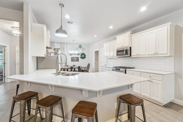 609 NW 180th St, Edmond, OK 73012 - kitchen with stainless steel appliances, tasteful backsplash, a peninsula, a kitchen bar, and white cabinets