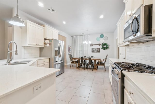 609 NW 180th St, Edmond, OK 73012 - kitchen featuring appliances with stainless steel finishes, tasteful backsplash, hanging light fixtures, recessed lighting, and light tile patterned flooring