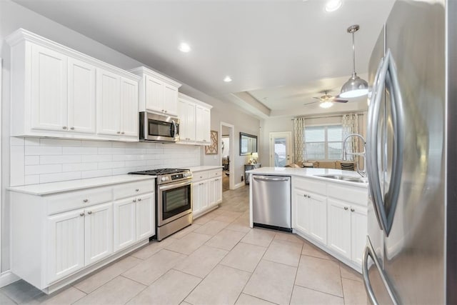 609 NW 180th St, Edmond, OK 73012 - kitchen with appliances with stainless steel finishes, ceiling fan, decorative backsplash, light countertops, and a peninsula