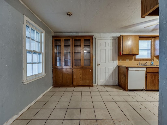 109 E Northrup Dr, Oklahoma City, OK 73110 - kitchen featuring dishwasher, brown cabinetry, light countertops, a textured wall, and crown molding