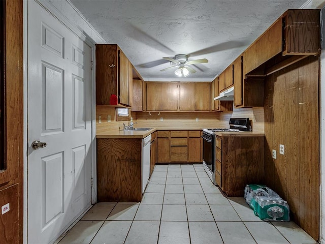 109 E Northrup Dr, Oklahoma City, OK 73110 - kitchen with range with gas cooktop, under cabinet range hood, brown cabinetry, light countertops, and a textured ceiling