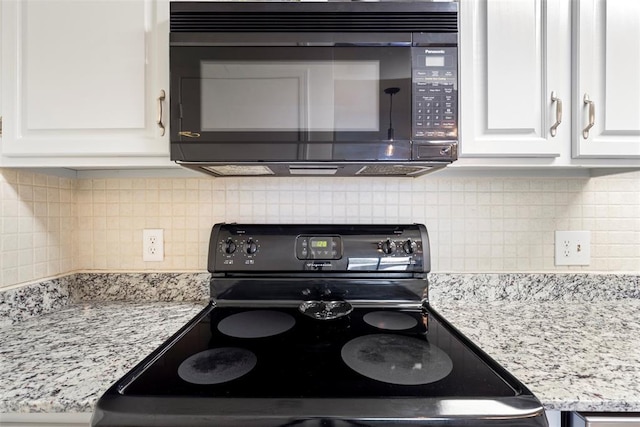 14405 N Pennsylvania Ave Unit 6D, Oklahoma City, OK 73134 - kitchen with electric range, black microwave, white cabinets, decorative backsplash, and light stone counters