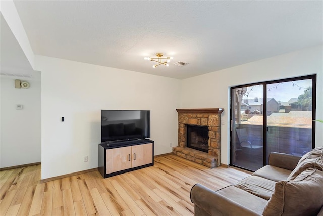 14405 N Pennsylvania Ave Unit 6D, Oklahoma City, OK 73134 - living area featuring light wood-style flooring and a stone fireplace