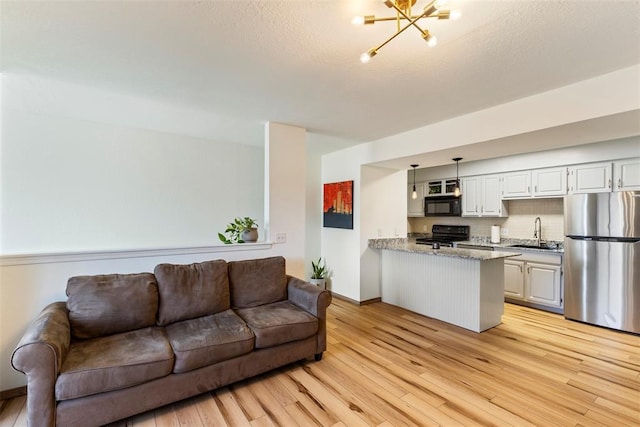 14405 N Pennsylvania Ave Unit 6D, Oklahoma City, OK 73134 - living room featuring light wood finished floors and a chandelier