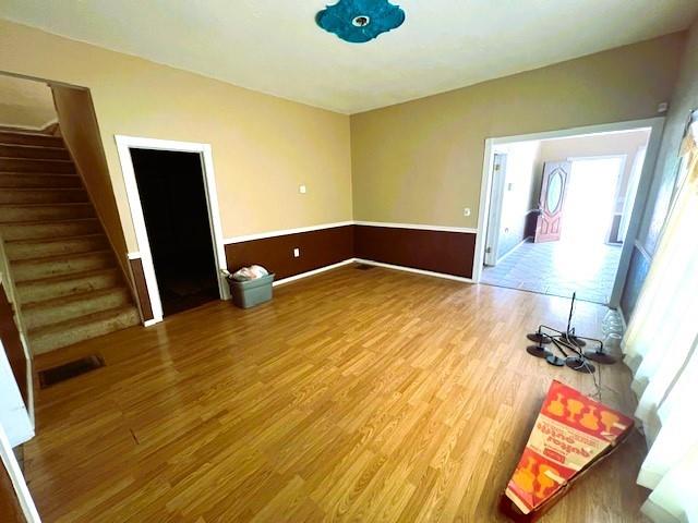 502 E Cavalry St, Cordell, OK 73632 - unfurnished living room featuring stairs and wood finished floors